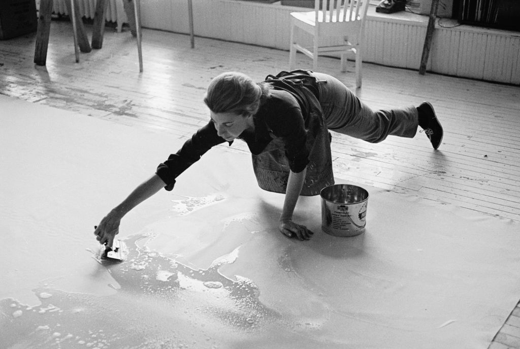 Abstract expressionist artist Helen Frankenthaler at work in her studio, painting on the floor.