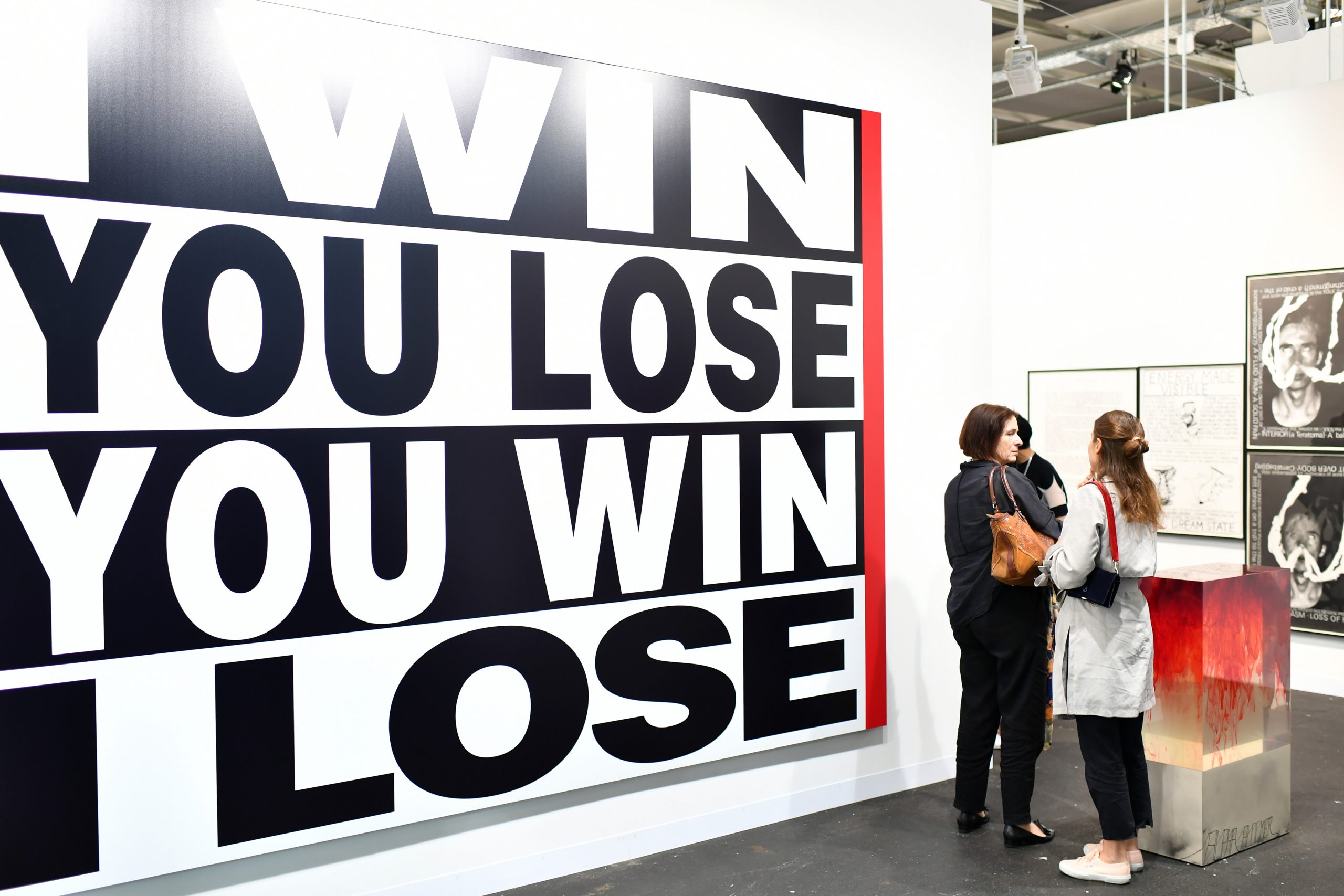 Visitors look at the artwork of Barbara Kruger "Untitled" during the press preview for Art Basel at Basel Messe on June 13, 2018 in Basel, Switzerland. Photo by Harold Cunningham/Getty Images.