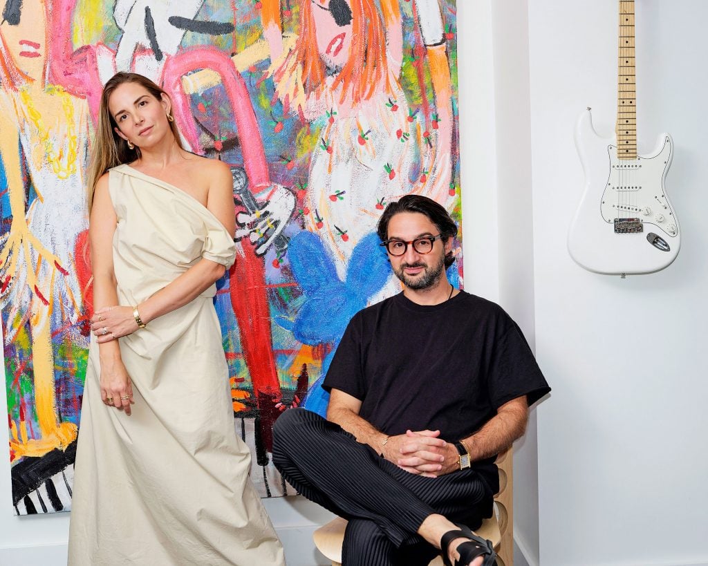 Tara and Jack Benmeleh with a painting by Yirui Jia, Up All Night (2022), in their Miami home.