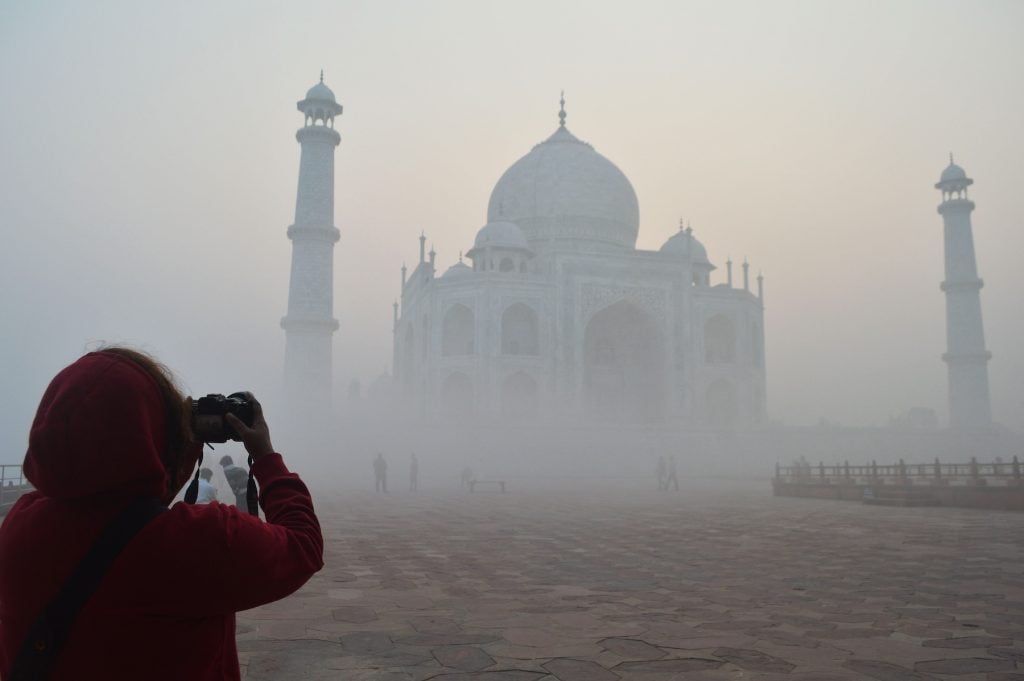 A tourist takes a picture of the Taj Maha