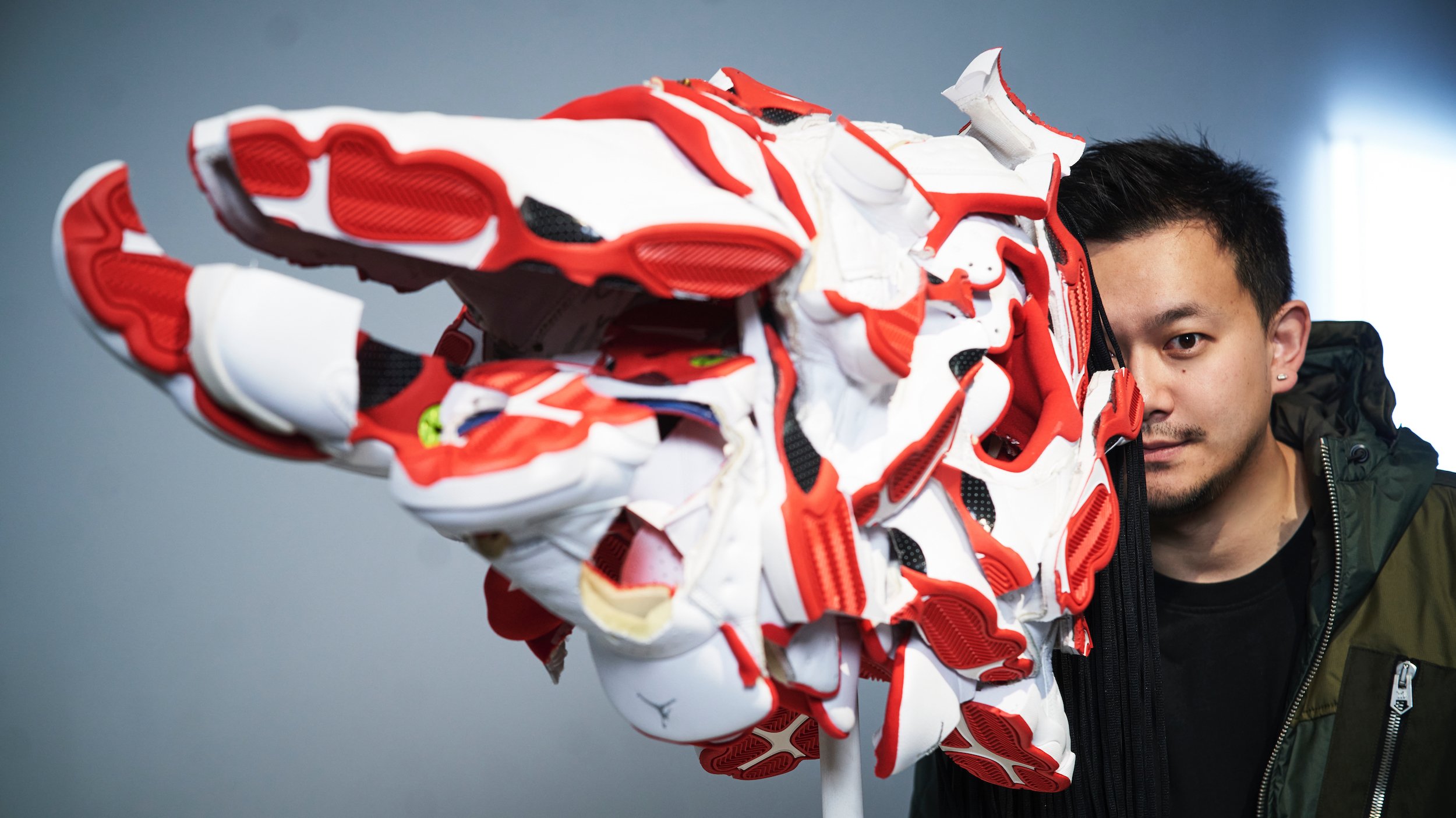 David Chau with Persuasion Mask (2018) by Brian Jungen, made of Nike Air Jordans. Courtesy of David Chau.