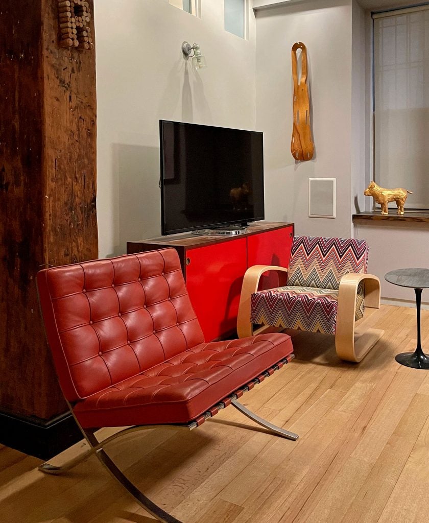 Loft interior with Mies van der Rohe's Barcelona Chair (1929), left, Alvar Aalto's Tank chair (1936) with Missoni upholstery, and an original Eames molded plywood leg splint (1943) on the wall.