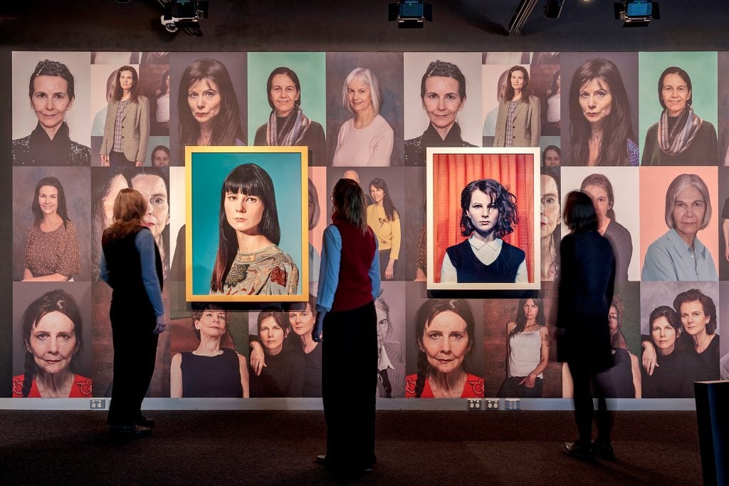 Installation view of Gillian Wearing's "Editing Life" with <em>Self Portrait of Me Now in Mask</em> (2011), <em>Self Portrait at 17 Years Old</em> (2003) and <em>Rock ‘n’ Roll 70 Wallpaper</em> (2015), presented as part of PHOTO 2022 in Melbourne, Australia. 
