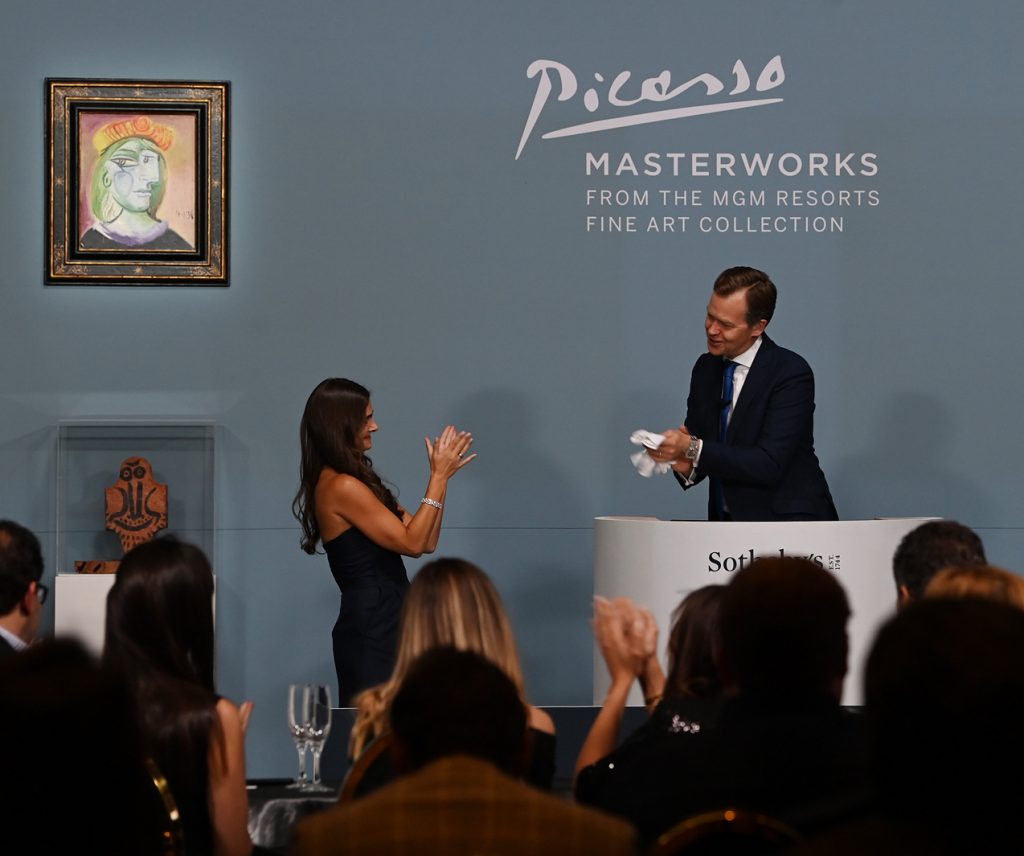 Brooke Lampley, Sotheby’s global chairman, delivered white gloves to auctioneer Oliver Barker after a successful auction in Las Vegas in 2021. Photo by Denise Truscello/Getty Images for Sotheby’s.