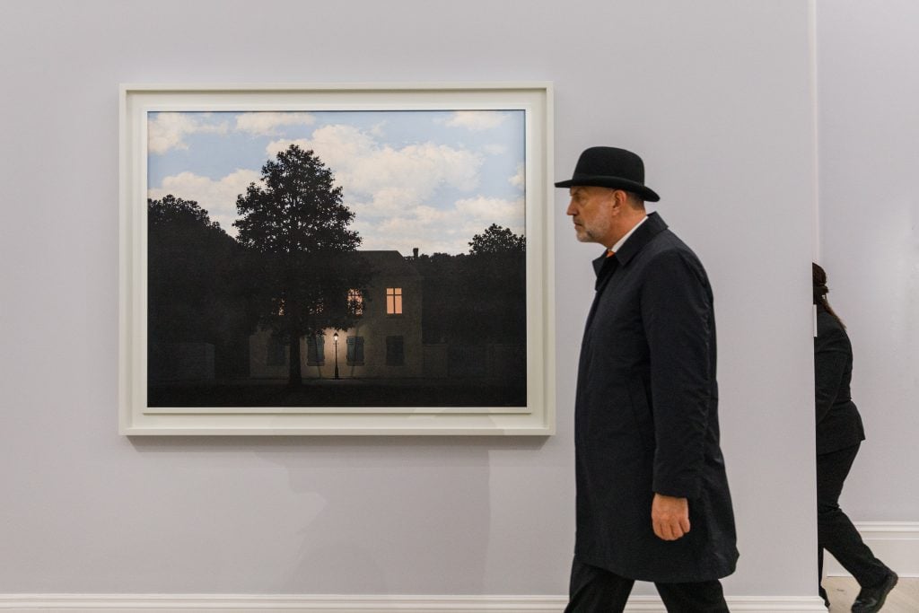 René Magritte’s L’empire des lumières’ is visited by a bowler hat-wearing man. Photo by Tristan Fewings/Getty Images for Sotheby's.