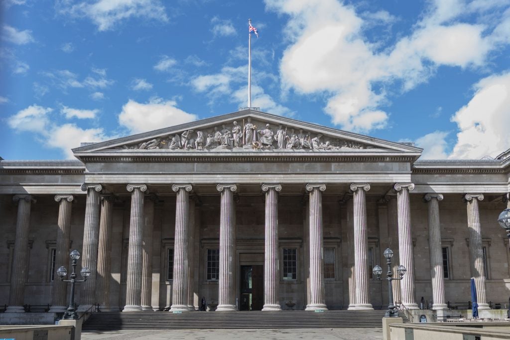 Photograph of the British museum exterior with a blue sky full of clouds
