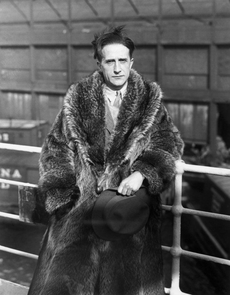 Artist Marcel Duchamp wearing a fur coat ahead of a trip to Paris.