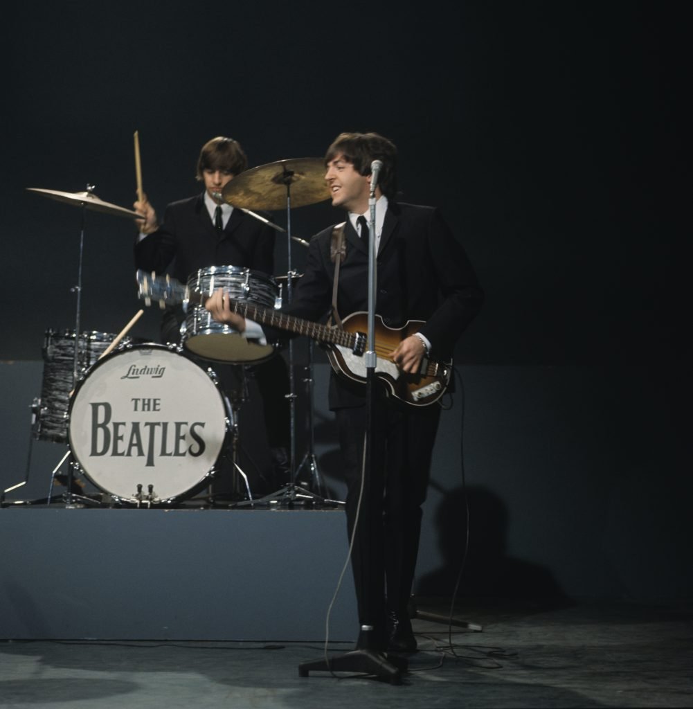 From left, Ringo Starr (playing Ludwig drum kit) and Paul McCartney (playing a Hofner 500/1 violin bass guitar) of English rock and pop group The Beatles perform together on stage during recording of the American Broadcasting Company (ABC) music television show 'Shindig!' at Granville Studios in Fulham, London on 3rd October 1964. The band would play three songs on the show, Kansas City/Hey-Hey-Hey!, I'm a Loser and Boys. Photo by David Redfern/Redferns.