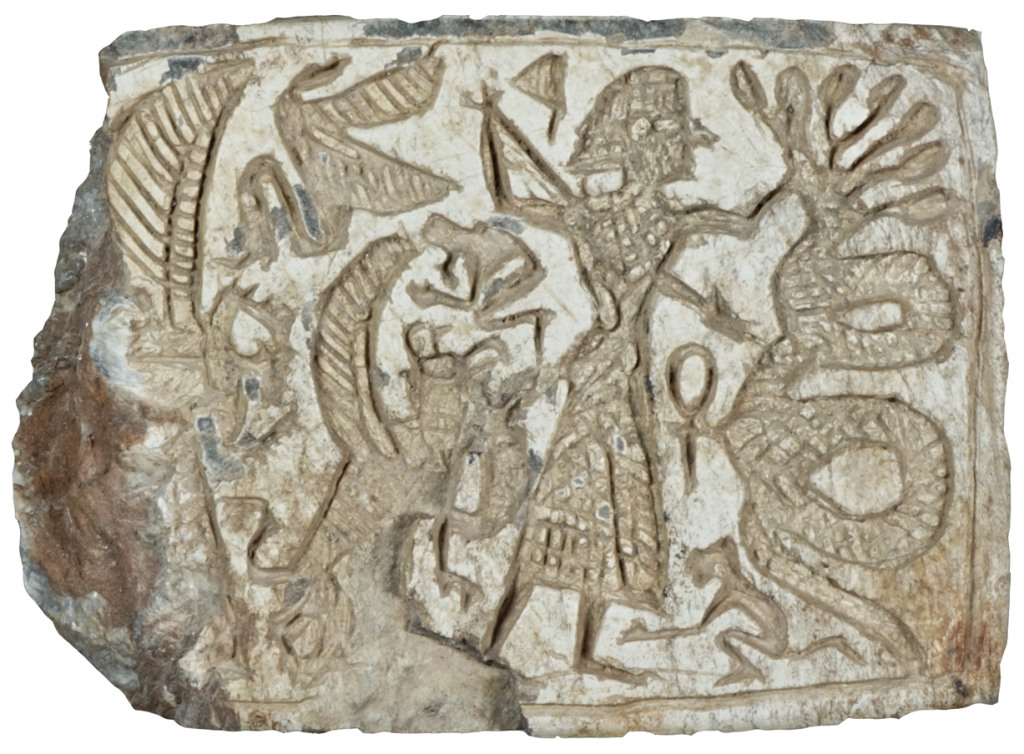 A photo of a tiny stone carving depicting a figure slaying.a serpent. Other animals stand behind them.