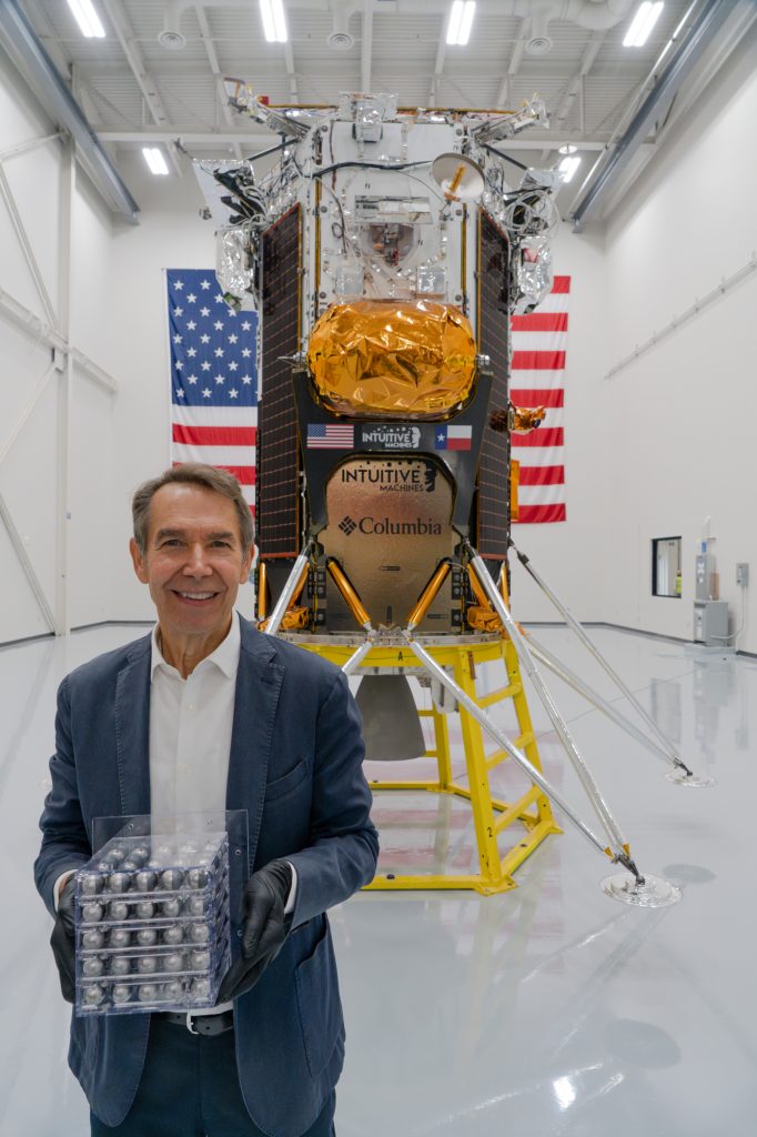 photo of jeff koons holding his sculpture moon phases infront of the space carrier