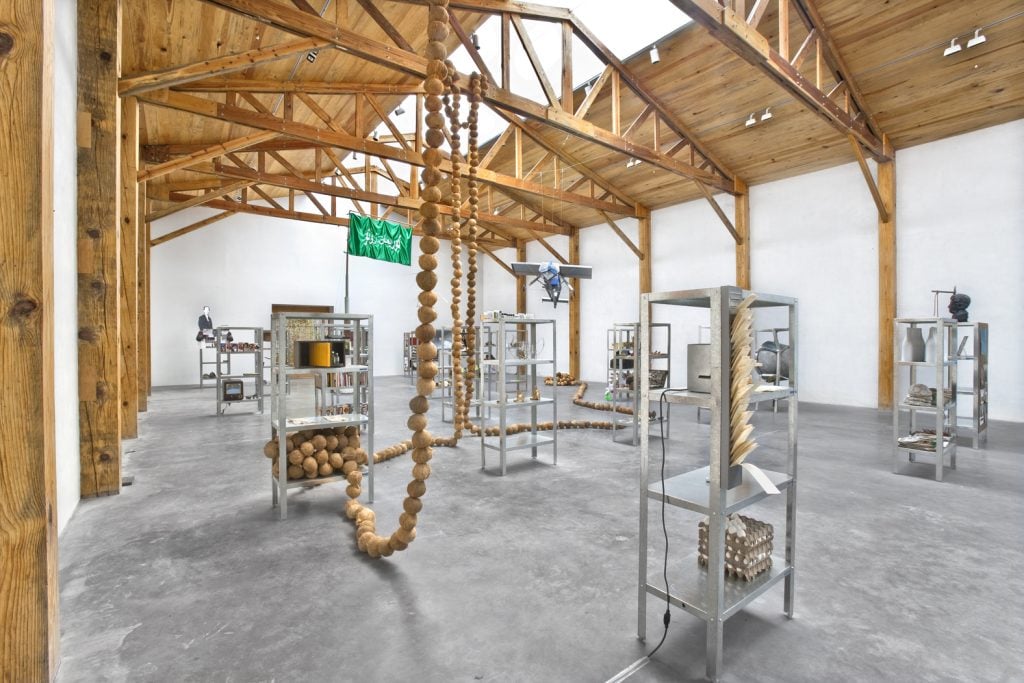 photograph of a gallery space with metal shelf towers throughout the space