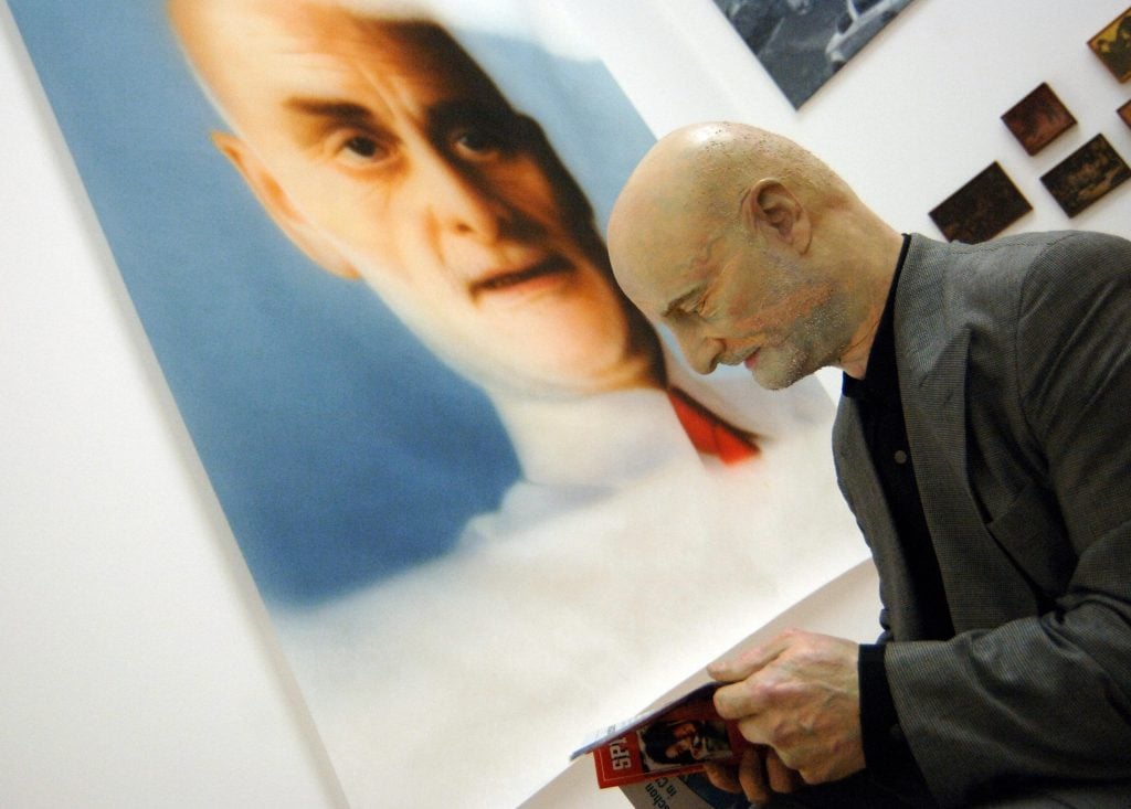 乌利·希克站在中国艺术家周铁海所画的肖像旁