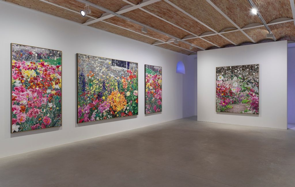 a room full of paintings of flowers in garish colors