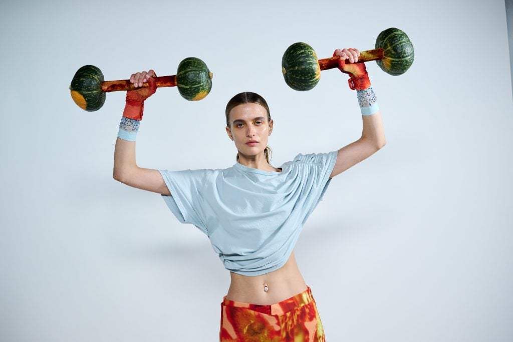 a model is using gourds for barbells