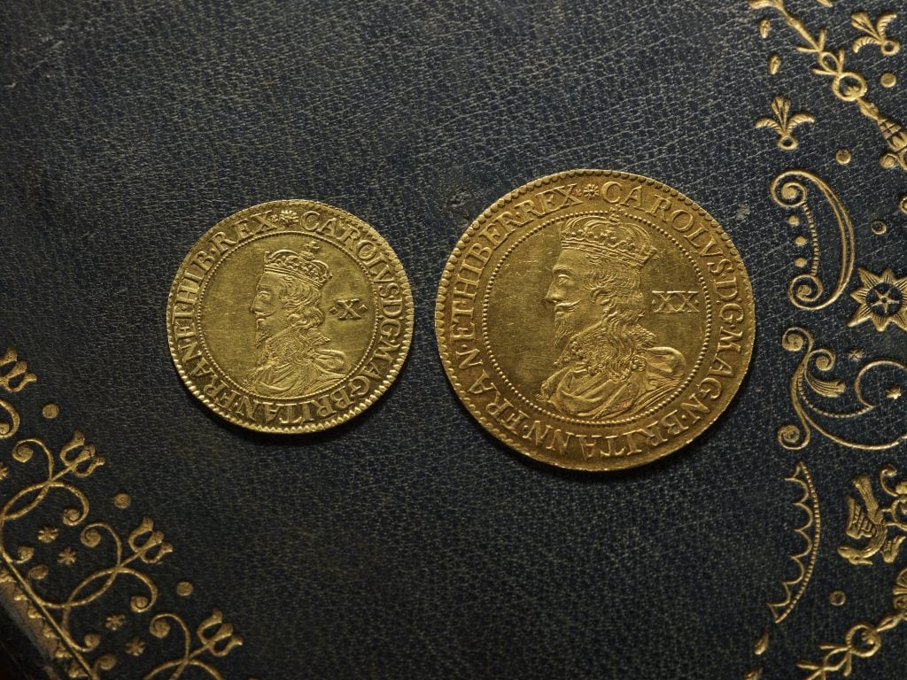 Two gold coins on a deep blue surface.