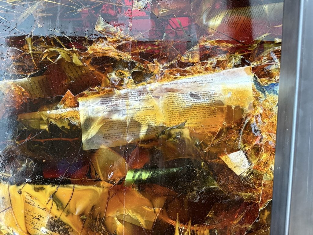Illegible documents suspended in amber