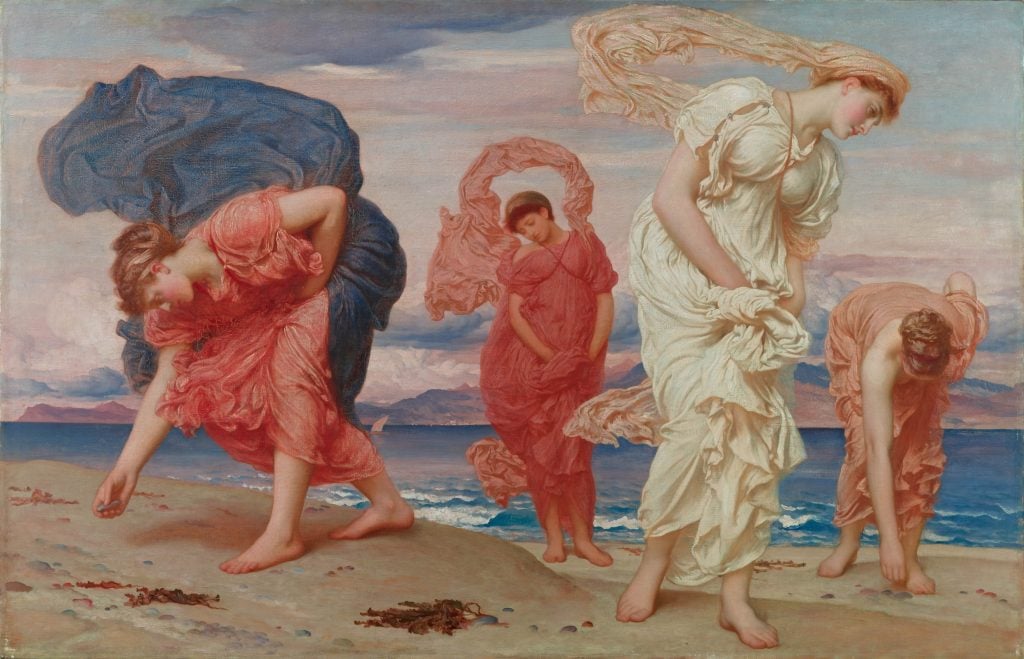 Four women in dramatically flowing gowns collect pebbles on a beach.