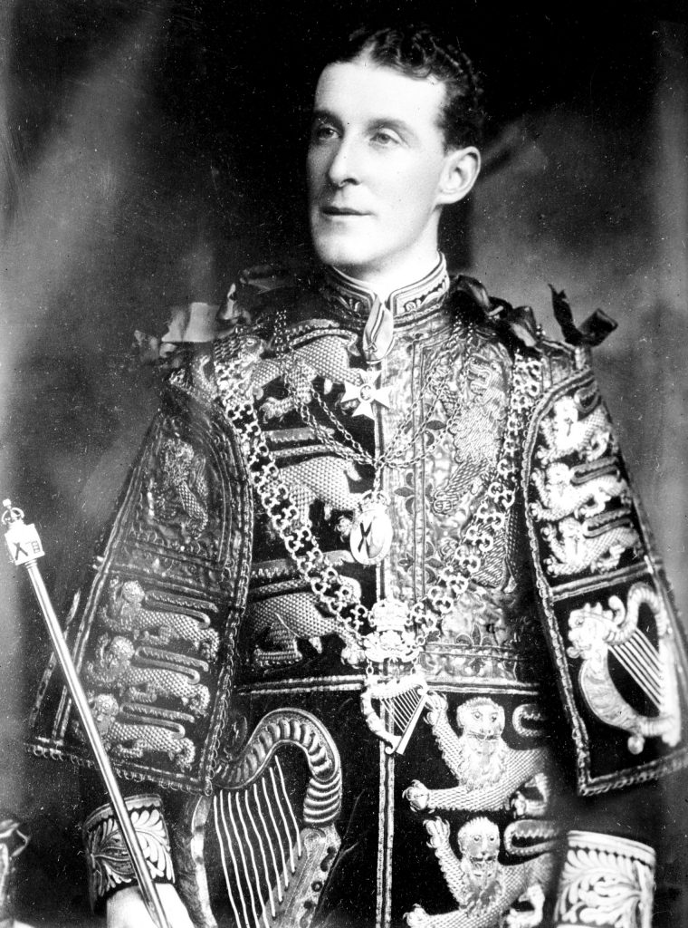 A portrait of Sir Arthur Vicars, depicted dressed in full royal regalia, a staff in his hand, and a blank expression on his face.