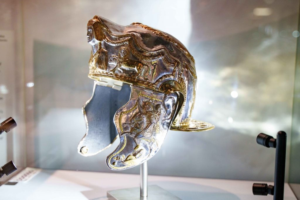 A handmade replica of an ancient Roman helmet, carved with images of lions