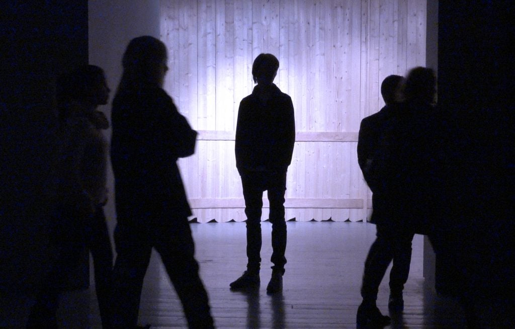 Curator Adam Szymczyk standing in a light installation