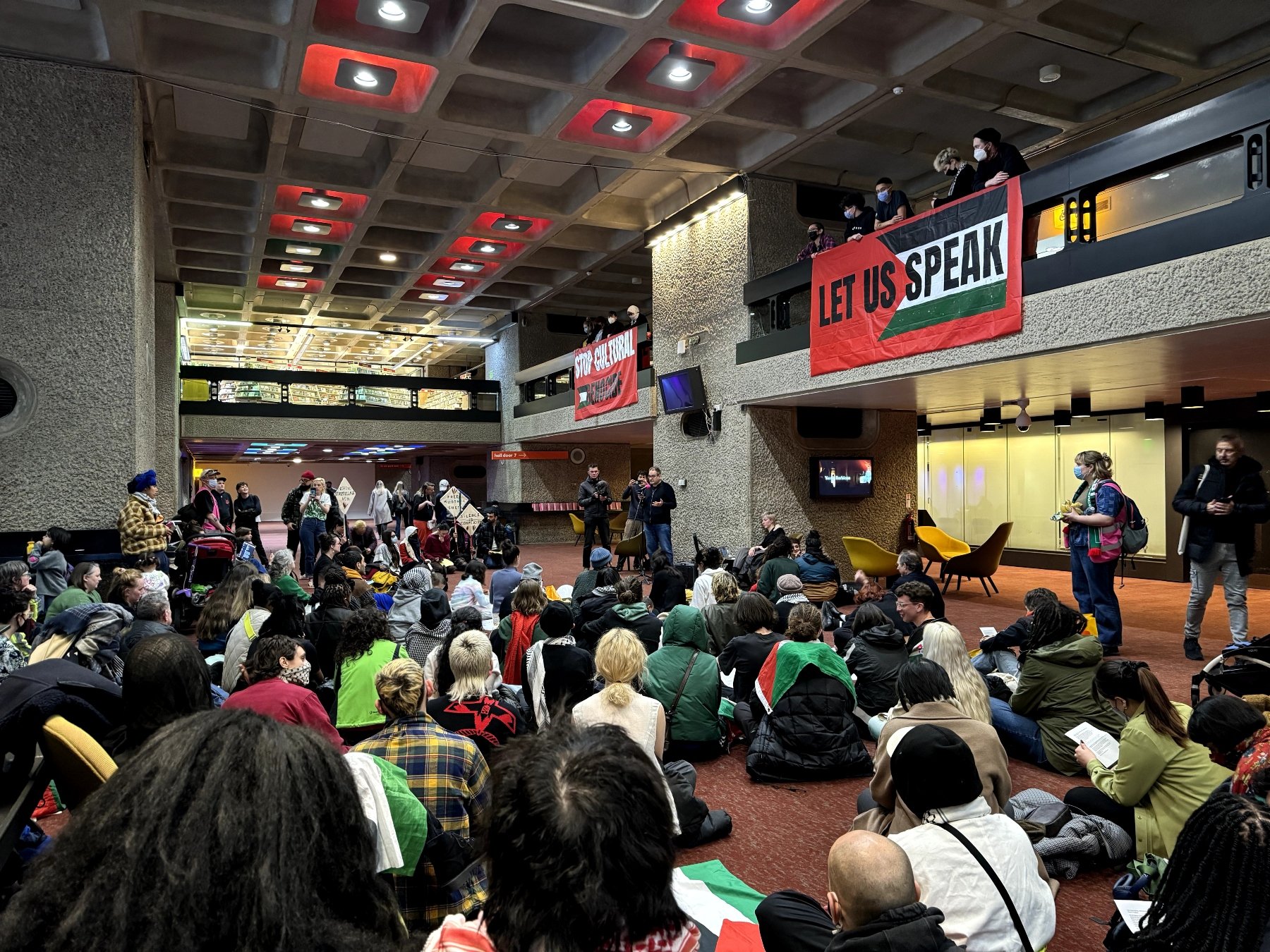 a large gathering of protestors with signs in support of Palestine