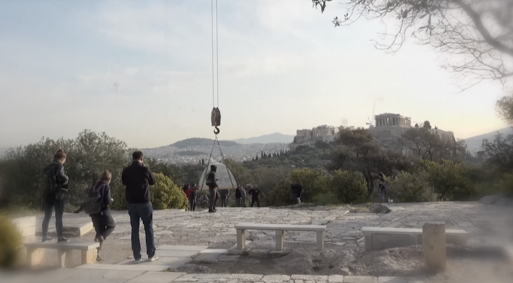 people installing an artwork near the acropolis in athens