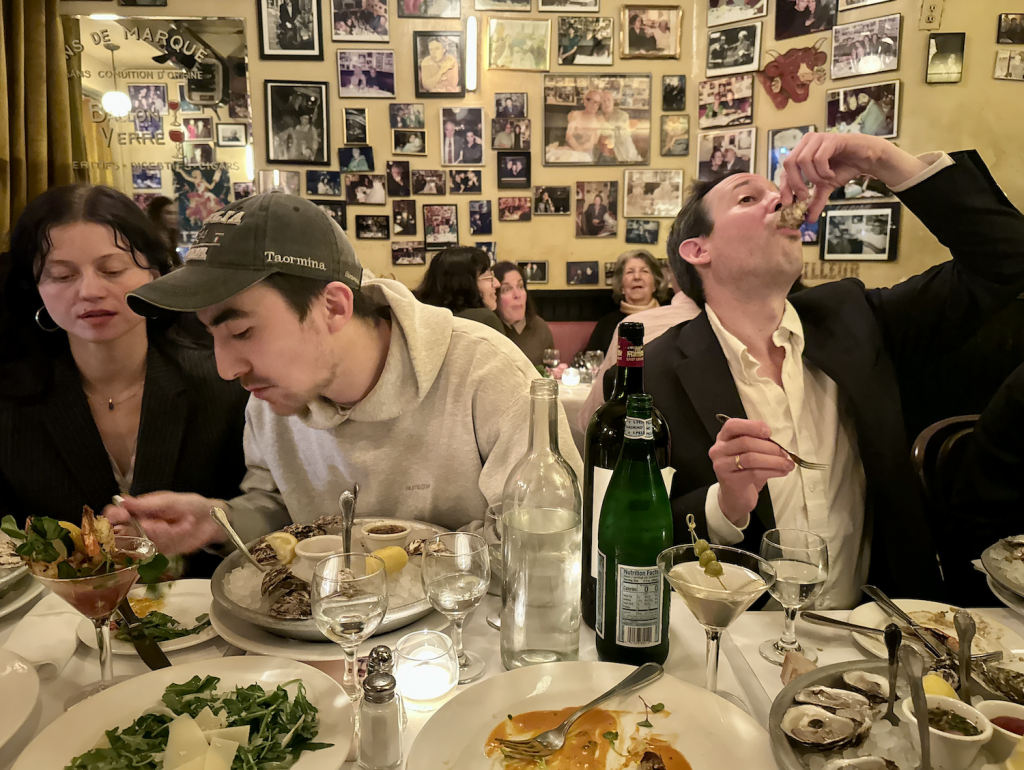 Guests eating oysters at New York City restaurant with pictures on the wall