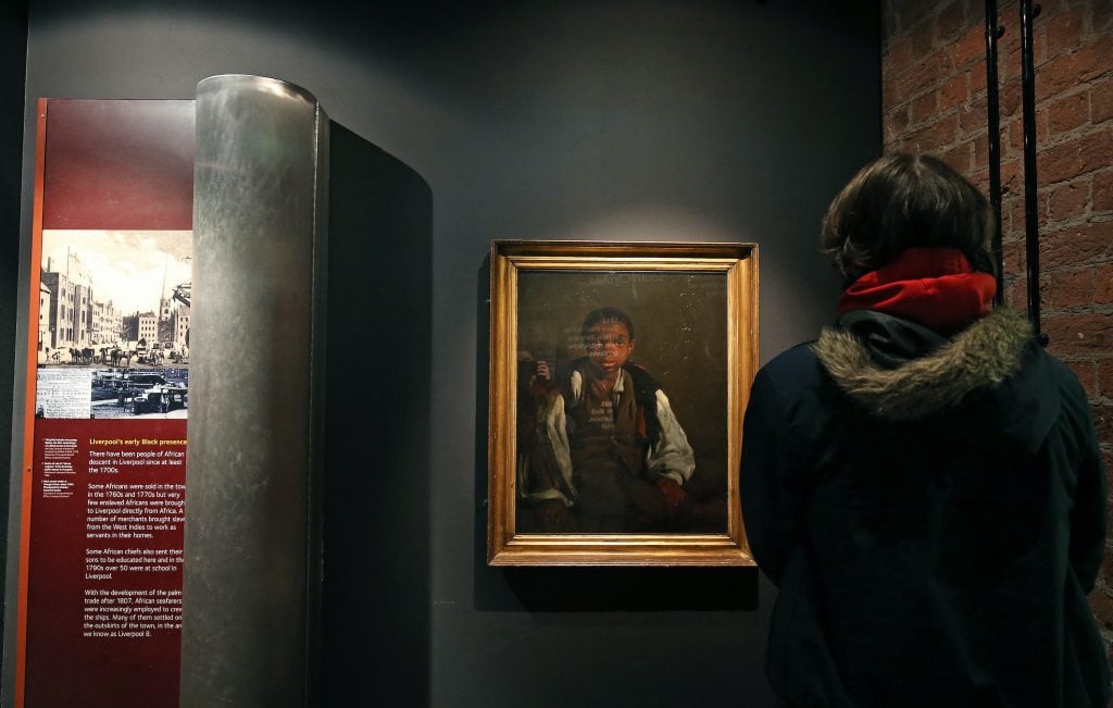 Visitor viewing the William Lindsay Windus portrait known as The Black Boy.