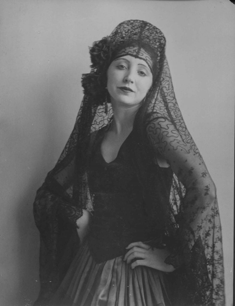 Author Anaïs Nin posing in a black dress with a black veil.