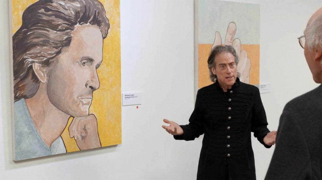 An elderly man standing next to his self-portrait, depicting a younger man.