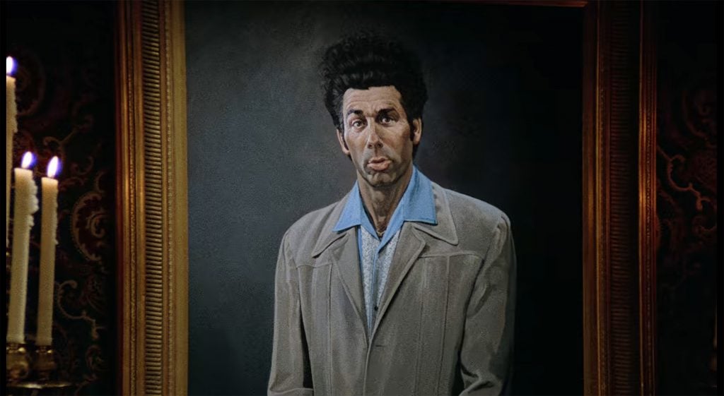 A portrait of a wild-haired, wild-eyed man in an oversized leisure suit.