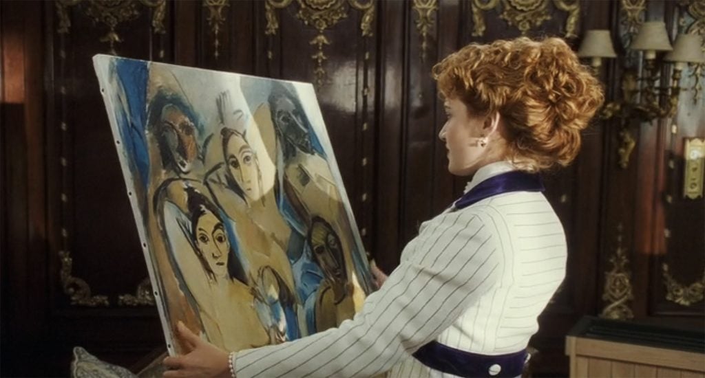 A smartly dressed woman holding up a Picasso painting.