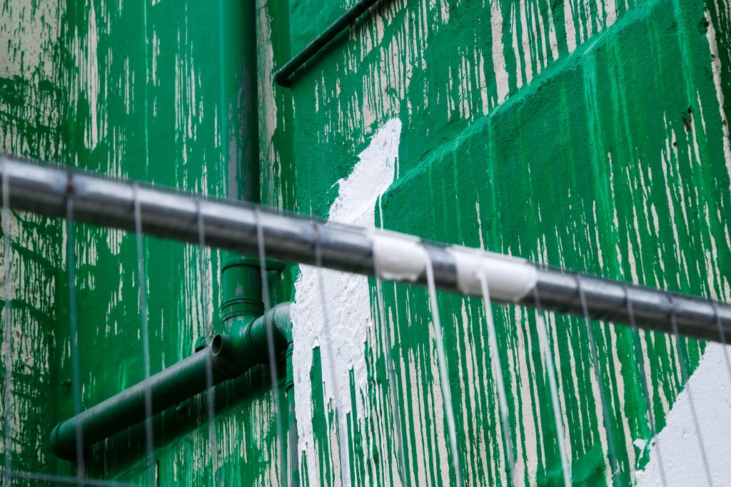 A splash of white paint against a green-painted wall