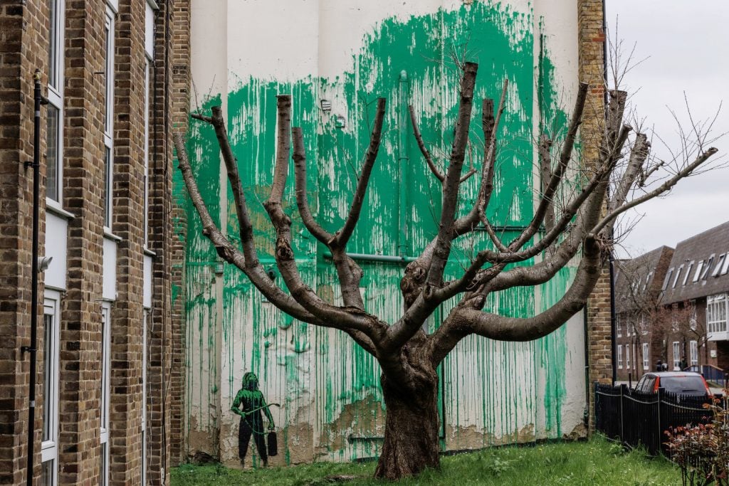 A new mural by Banksy, in which green paint serves as the foliage for a tree without leaves