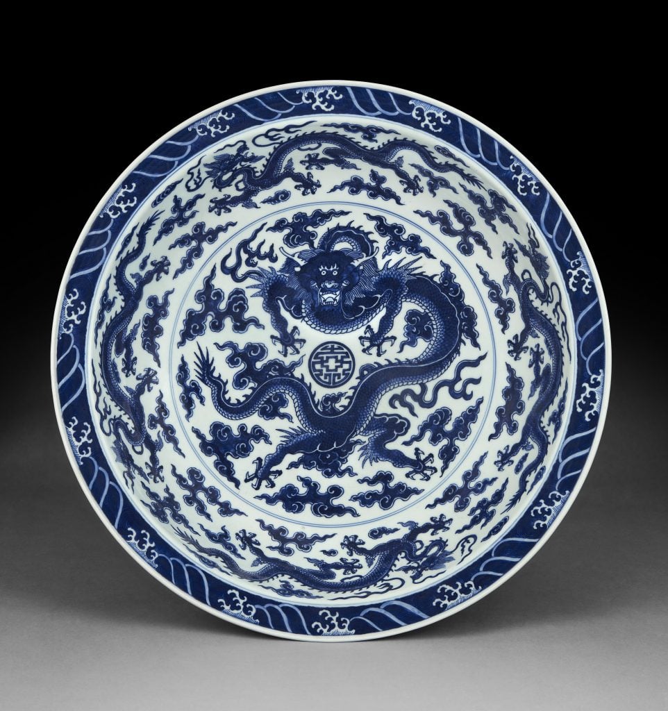 a blue and white plate with a dragon motif at the center