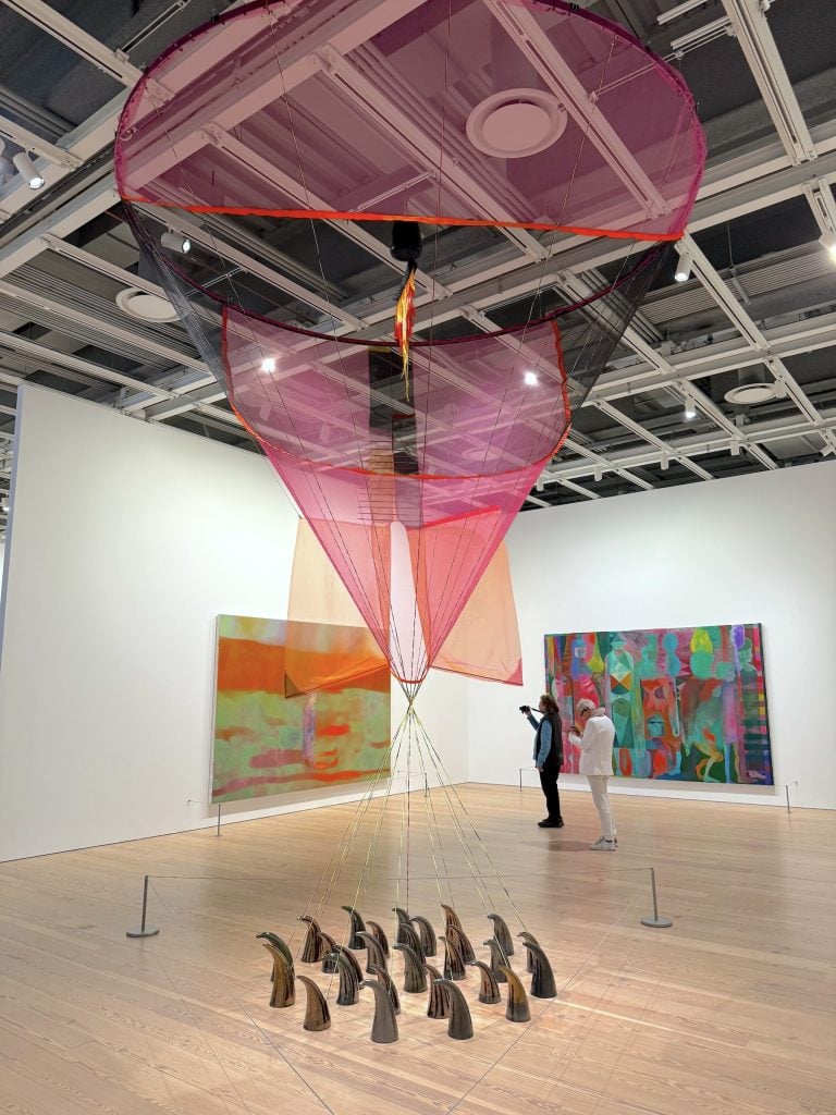 A sculpture of a cone of pink nylon hanging from the ceiling