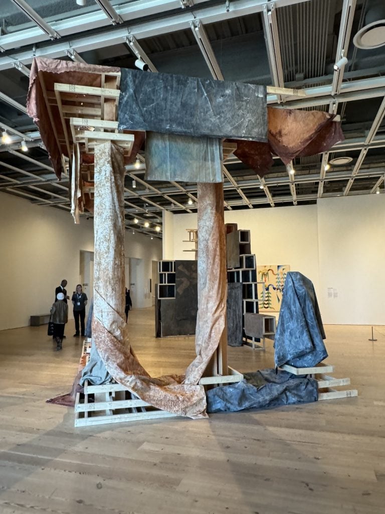 A sculpture of a set of freestanding pillars draped with cloth