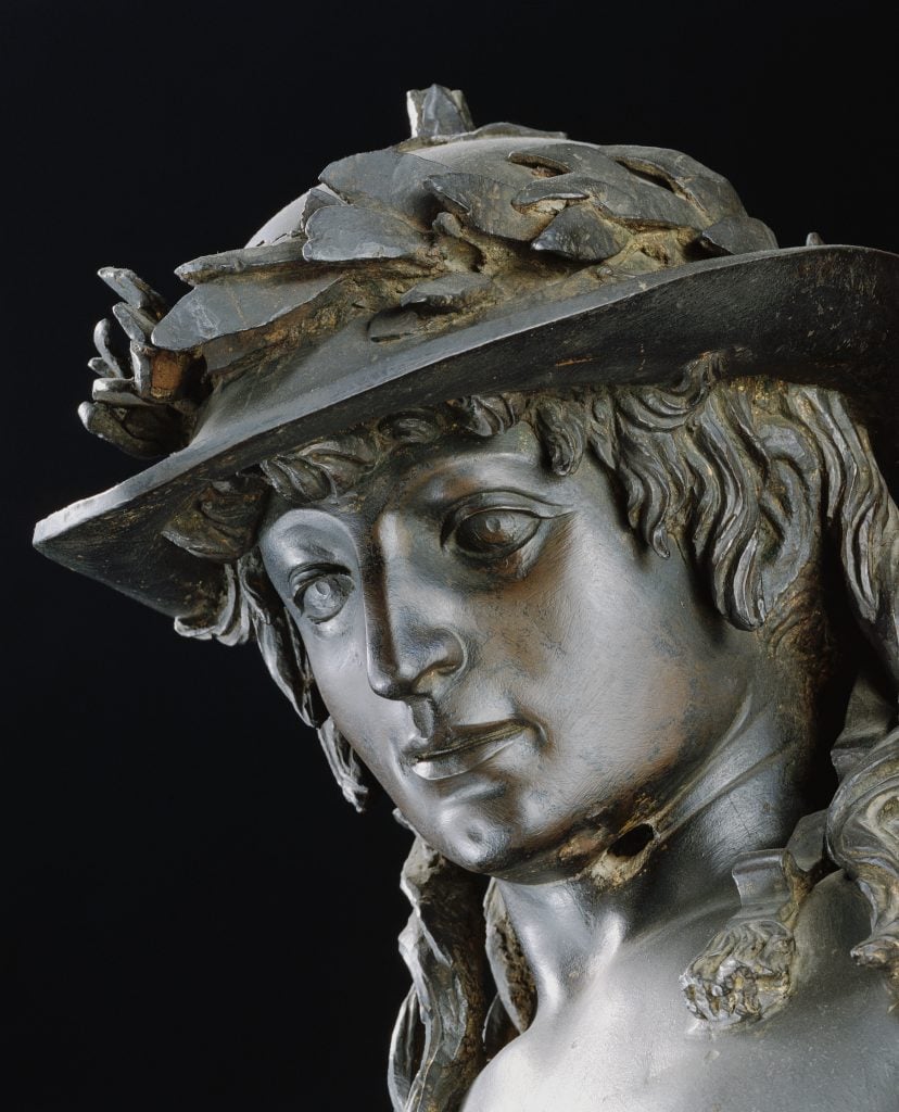 Close-up of Donatello's bronze sculpture David, depicting a young man with long hair and a helmet.