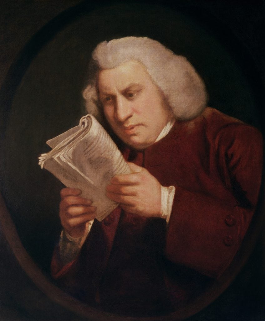 Samuel Johnson, a man in a white wig, gazing intently at a book held up close to his face.