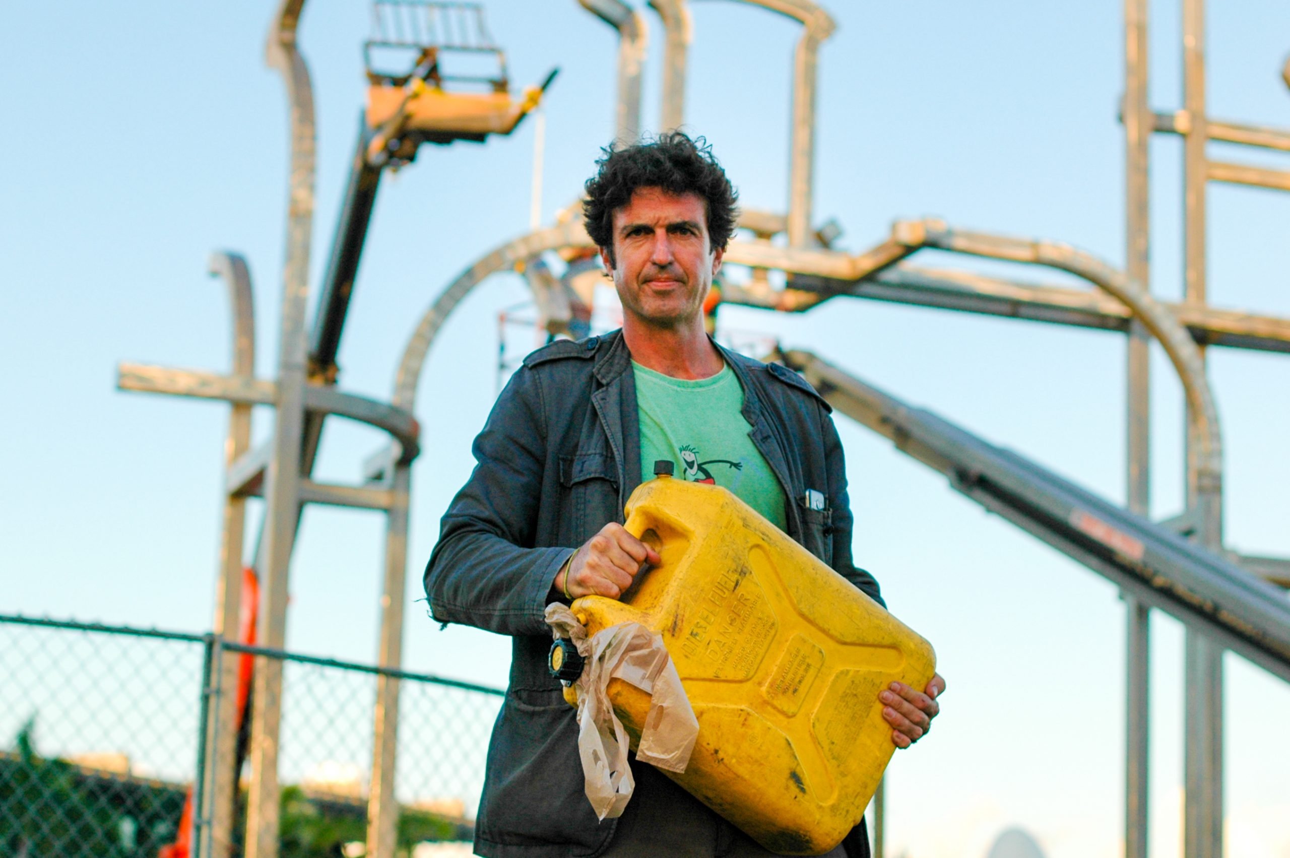 A man stands in front of a massive steel installation.