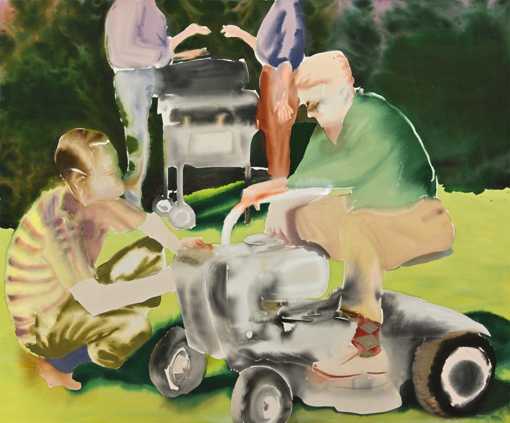 One man seated on a mower while another crouches next to him in conversation. The bodies of two men in the background next to a grill seemingly conversin.