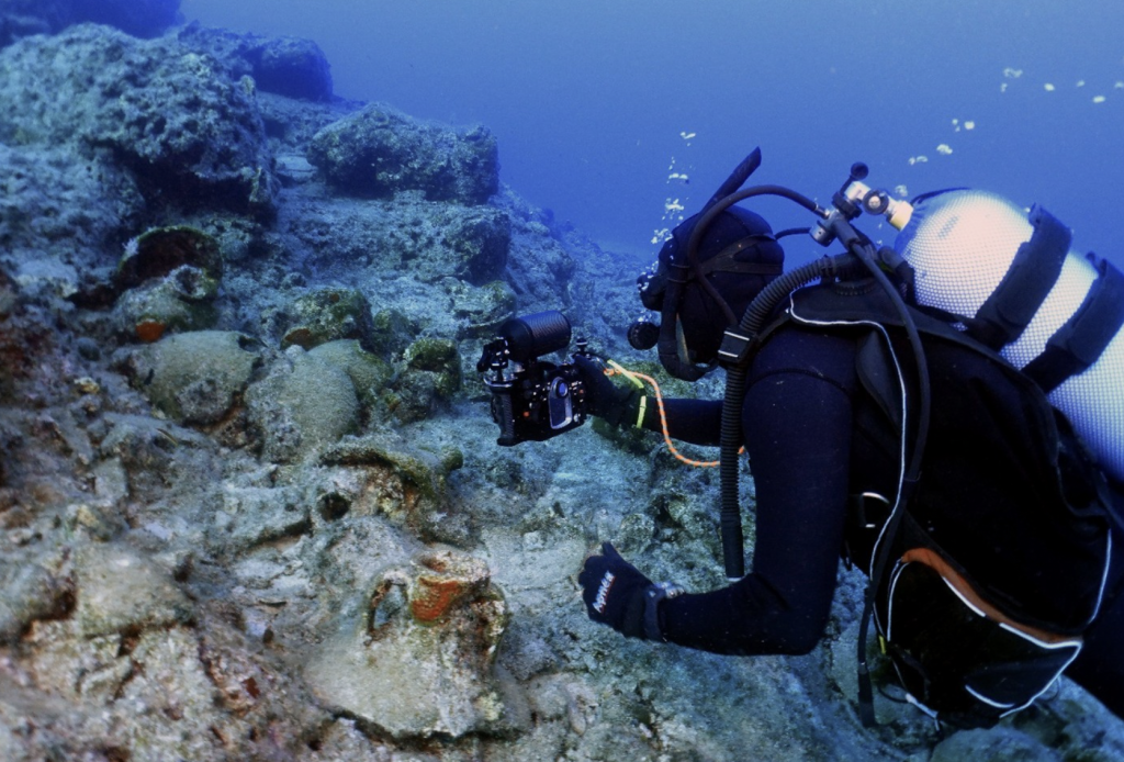A photo of an underwater diver photographing archaeological remains off the coast of Kasos, Greece