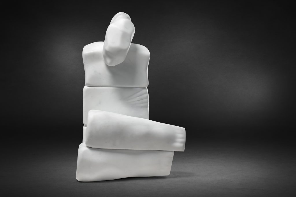 sculpture in white carrara marble of an abstract figure with legs crossed