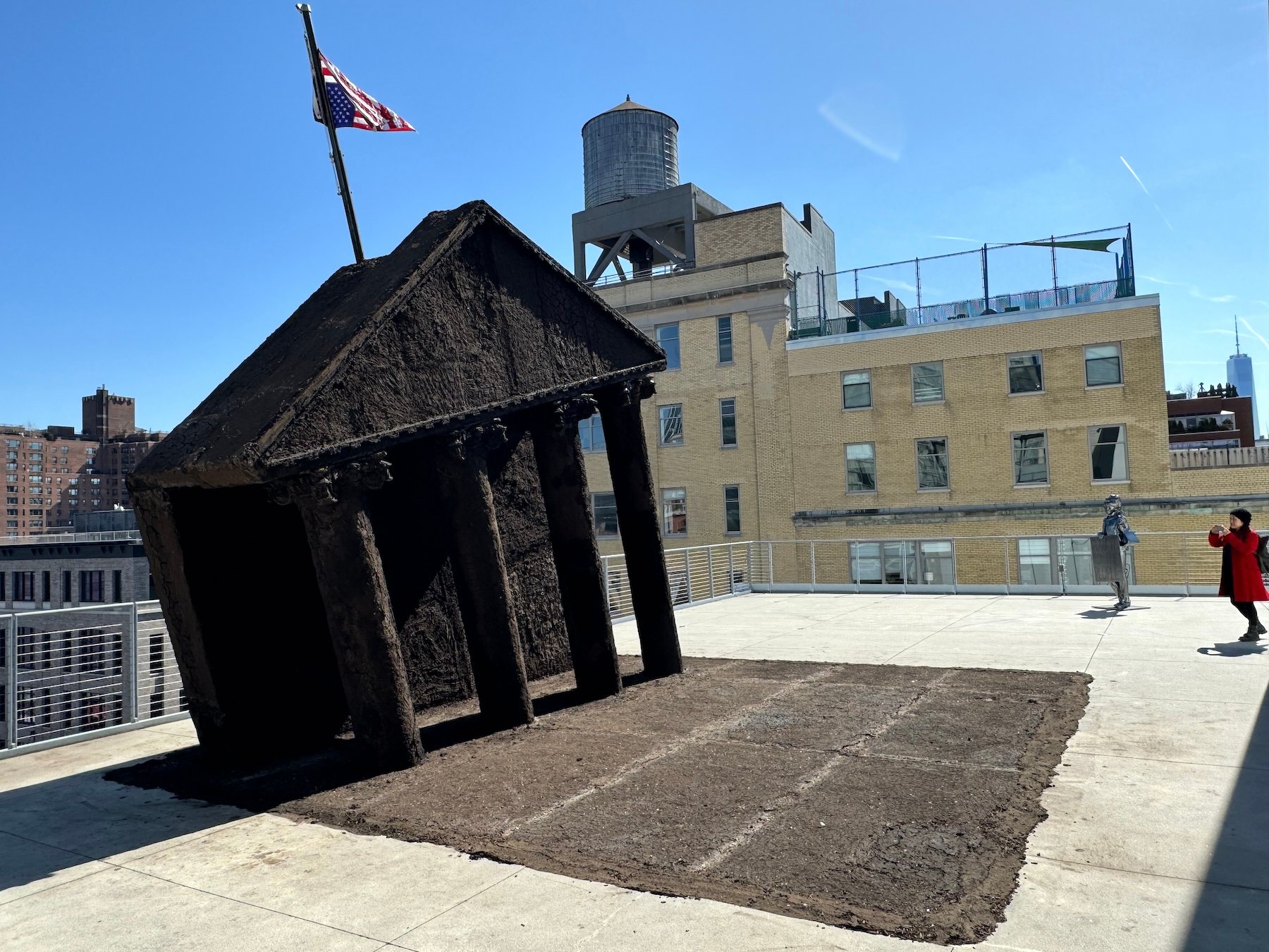 A sculpture of the front of the White House made from earth with an upside-down flag