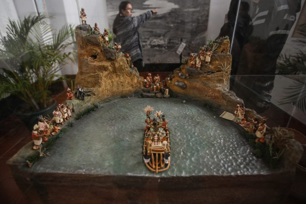 A diorama with figurines depicting the people of Muisca surrounding a lake.