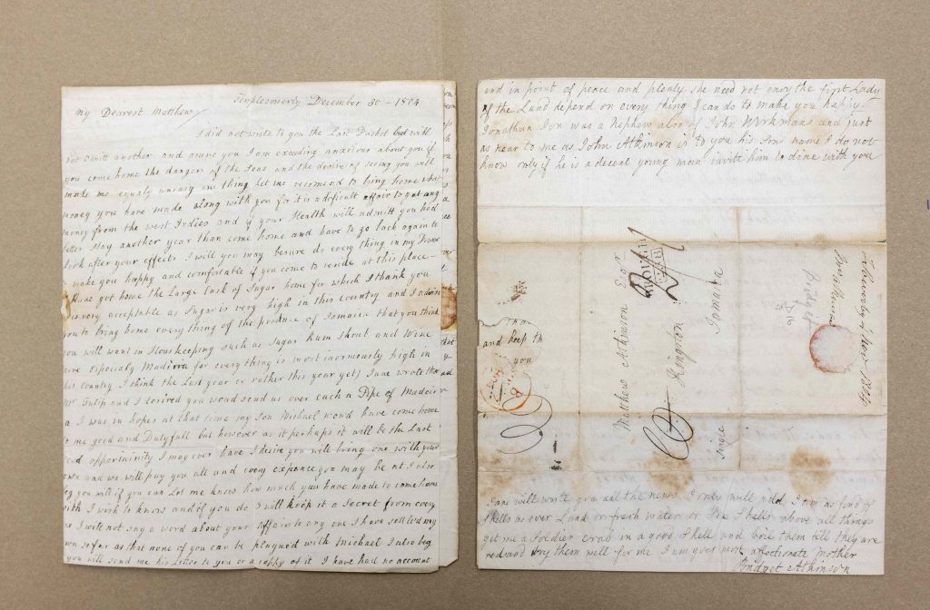 A photograph of two pages of a handwritten letter from Bridget Atkinson to son Matthew on a beige background