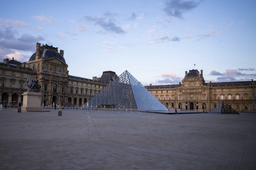 a stately building and a glass pyramid