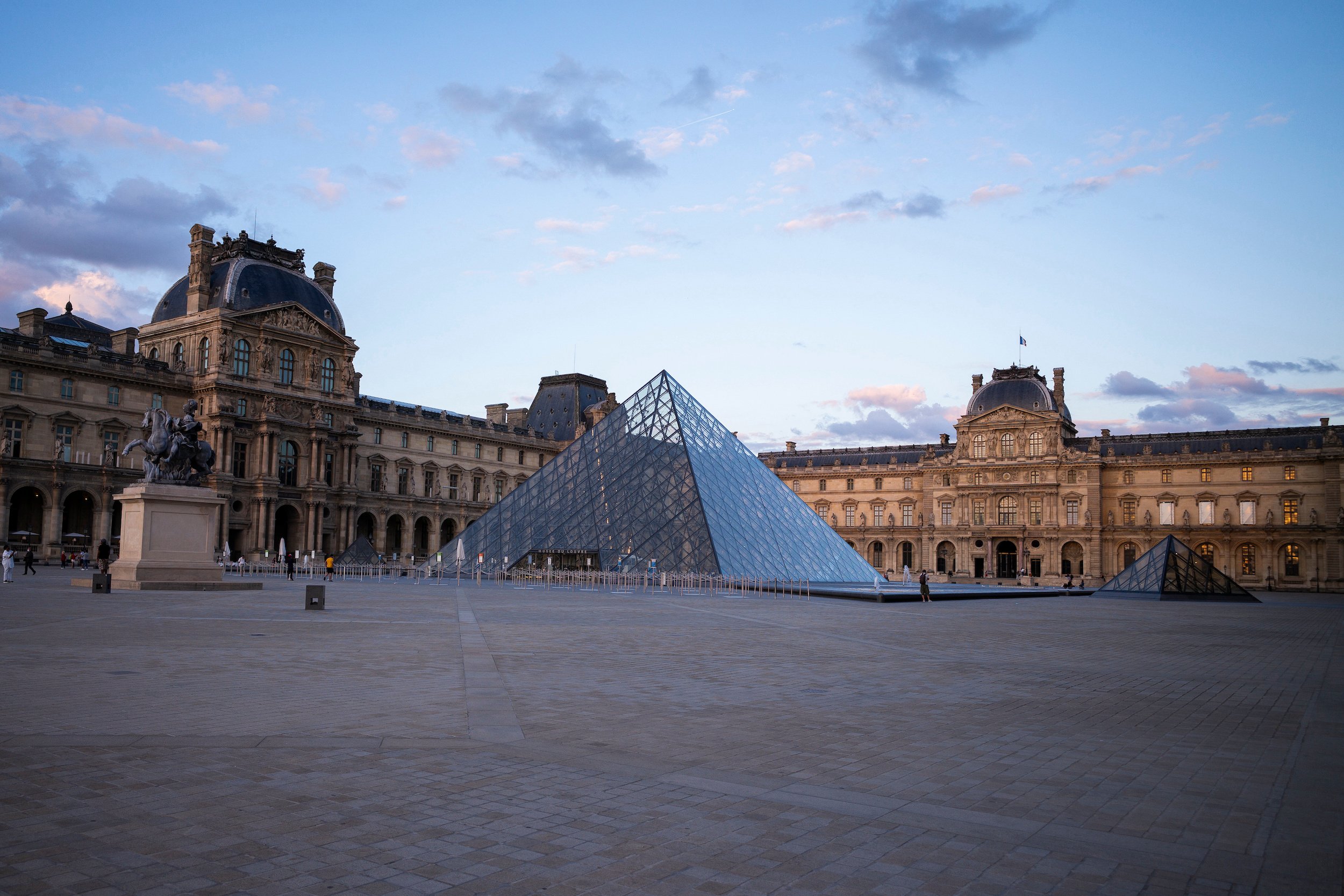 a stately building and a glass pyramid