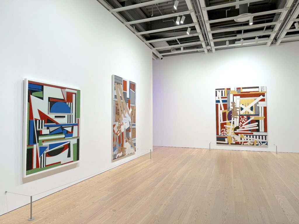 Three abstract paintings in an art gallery