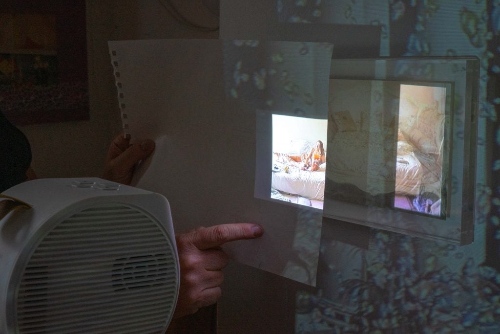 The process of projecting images onto a sheet of paper, showcasing the person's technique of layering visual elements.